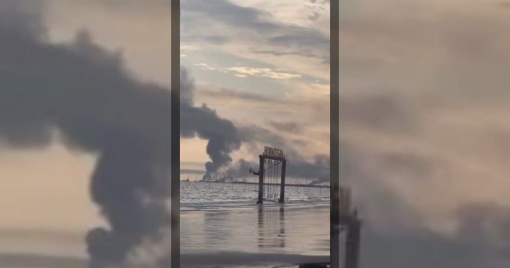 Символ войны: иранская девочка беззаботно качается на качелях на пляже в Бендер-Аббасе, пока рядом горит база КСИР